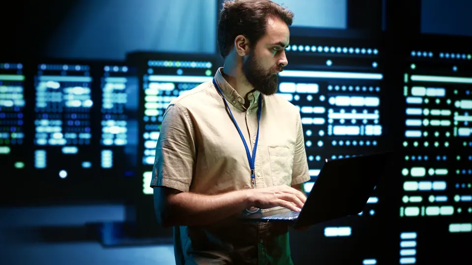 Close up of adept technician using laptop to check operational server hub