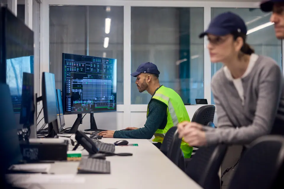 Engineers are working in the factory's control room