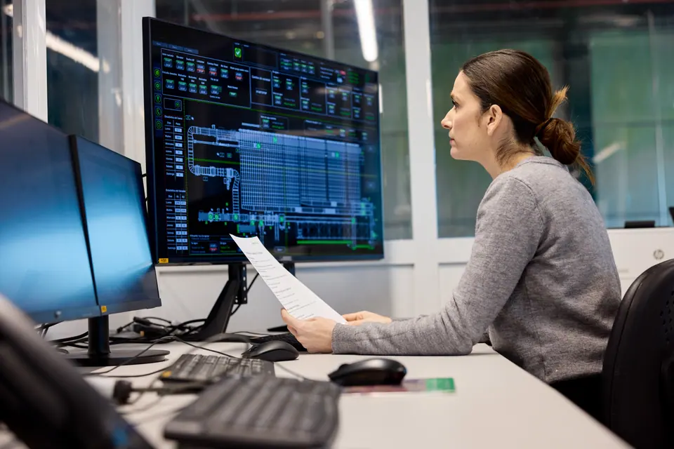 Engineers are working in the factory's control room