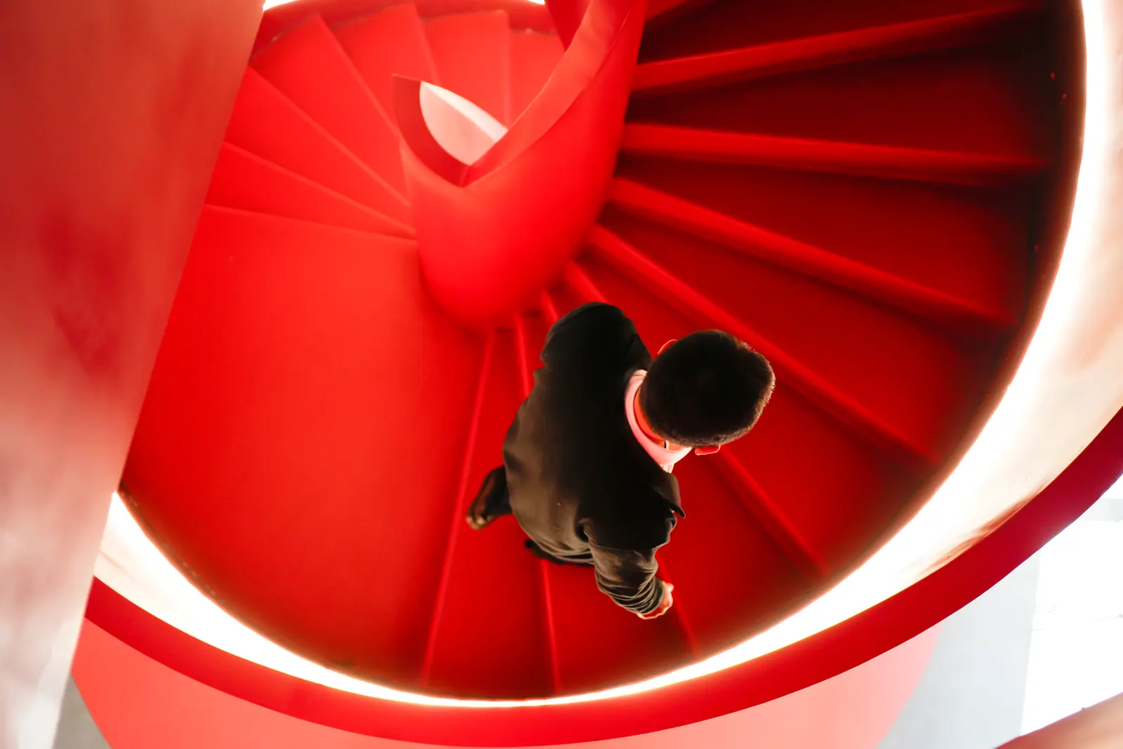 Overhead view of a person on curved red stairs